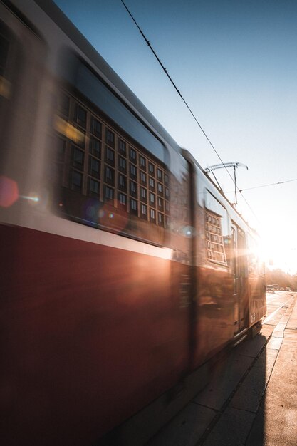 Verschwommene Bewegung der Straßenbahn auf der Straße gegen klaren Himmel