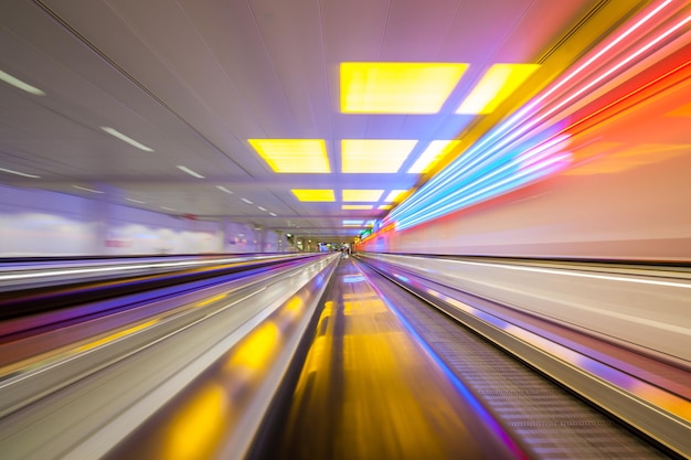Verschwommene Bewegung des beleuchteten beweglichen Gehwegs am Flughafen
