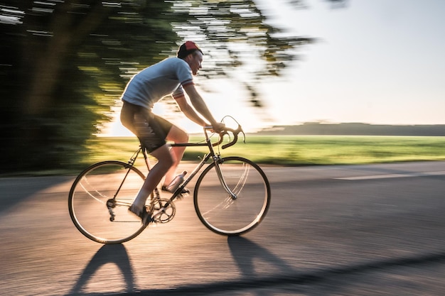 Foto verschwommene bewegungen eines fahrradfahrers auf der straße an einem sonnigen tag