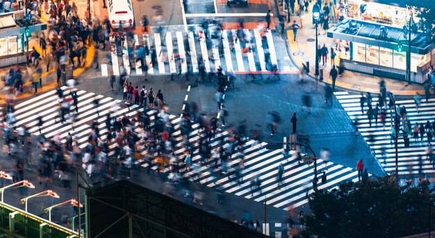 Verschwommene Bewegungen von Menschen, die die Straße in der Stadt überqueren