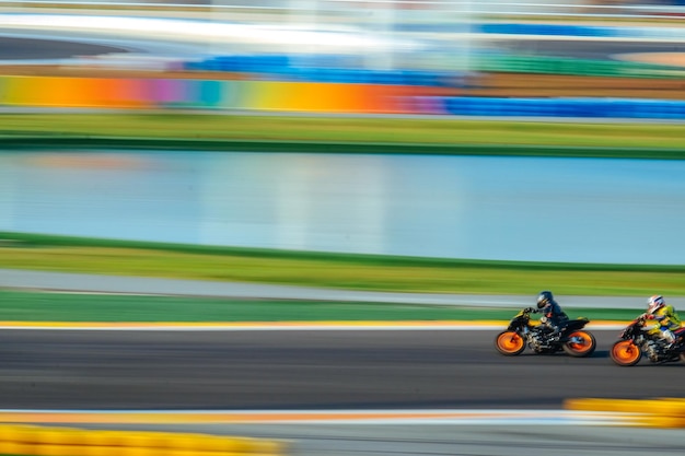 Verschwommene Bewegungen von Sportlern, die auf Motorrädern beim Rennen fahren