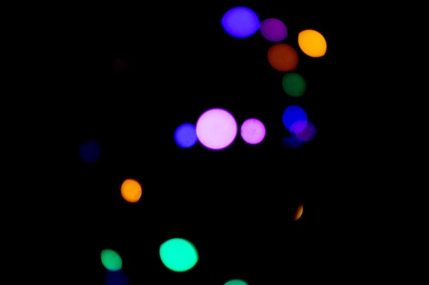 Verschwommene Lichter, schönes Bokeh auf einem schwarzen Hintergrundglitzern der Nachtstadt