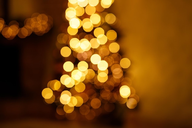 Verschwommene Sicht auf den Weihnachtsbaum im dunklen Innenraum Festlicher verschwommener Bokeh-Hintergrund