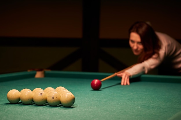 Verschwommene Silhouette eines Mädchens, das Billard spielt