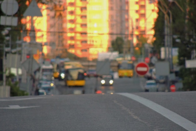 Verschwommene Stadtstraße mit Autoverkehr am sonnigen Tag