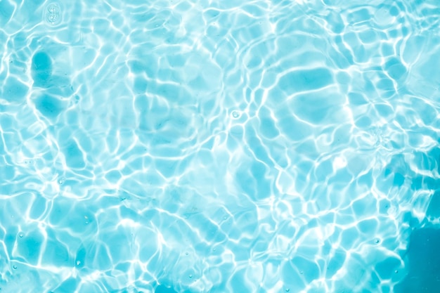 Verschwommene, transparente, blau gefärbte, klare, ruhige Wasseroberflächenstruktur mit Spritzern und Blasen Trendiger abstrakter Naturhintergrund Wasserwellen im Sonnenlicht Wasserhintergrund