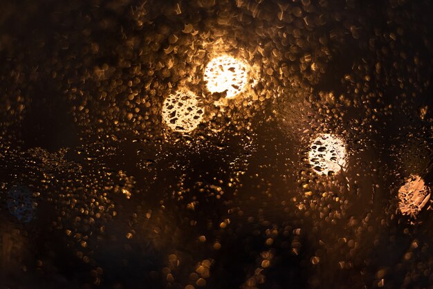 Verschwommener Hintergrund mit Regentropfen und Lichtern