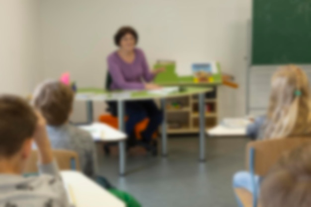 Foto verschwommenes bild von schulkindern, die im unterricht im unterrichtshintergrund zurück zur schule sitzen