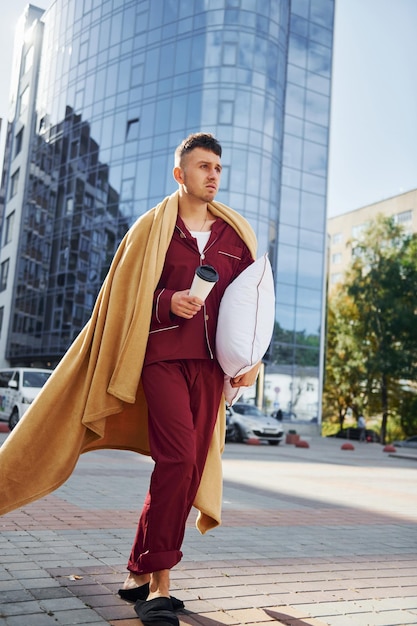 Verspätung für die Arbeit Junger Mann im Pyjama ist draußen auf der Straße Fühlt sich schläfrig an