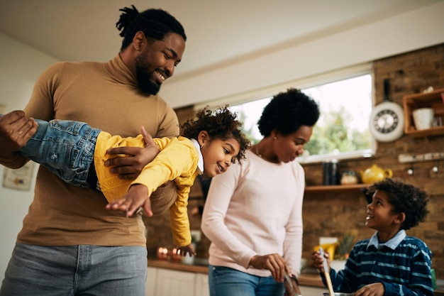 Verspielte afroamerikanische Familie, die sich zu Hause amüsiert