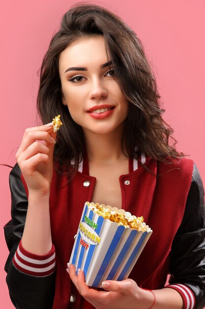 Verspielte Frau mit Packung Popcorn