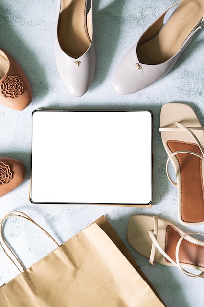 Verspotten Sie den leeren leeren digitalen Tablet-Bildschirm auf beige Modefrauen stilvoll