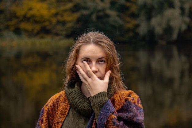 Versteckspiel das Mädchen bedeckte ihr Gesicht mit ihren Händen Closeup Portrait auf einem See Hintergrund Das Konzept der weiblichen Schmerz Traurigkeit Gewalt Depression Einsamkeit