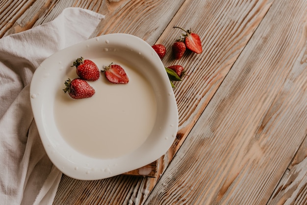 Verstreute saftige frische Erdbeeren auf dem Tisch mit Vintage-Planke