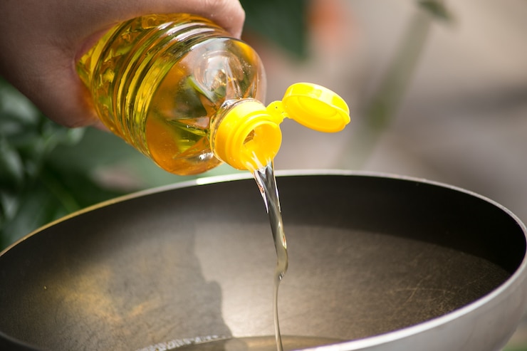 Foto verter el aceite de los alimentos en una sartén caliente para freír.