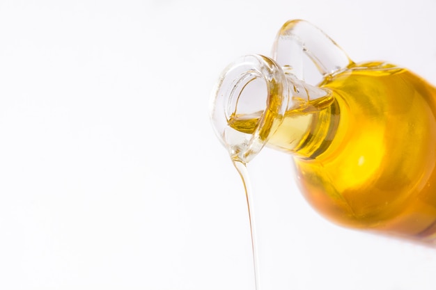 Verter aceite de oliva virgen aislado en blanco