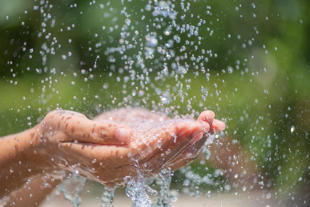 Verter agua en las manos de la mujer