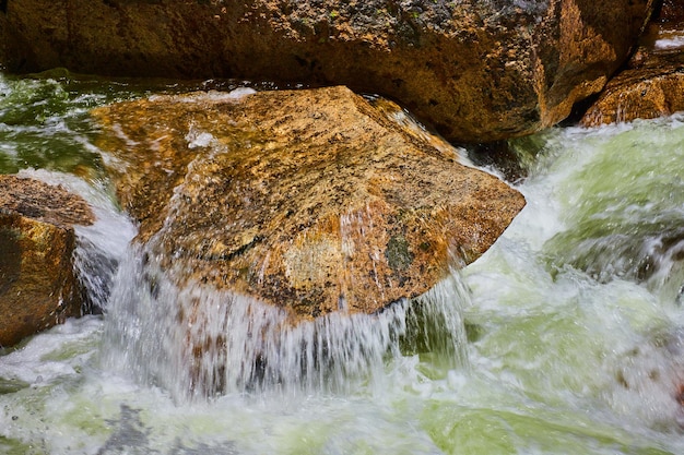 Verter agua en el río sobre afloramiento de roca