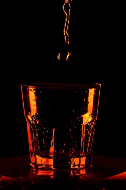 Verter agua en un vaso. Vaso de whisky con agua