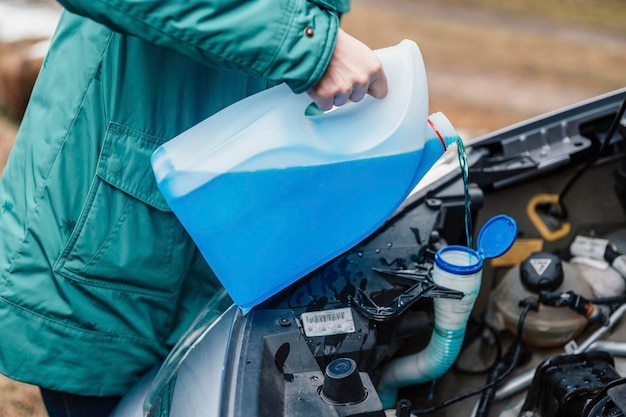 Verter anticongelante Llenar un tanque de lavado de parabrisas con un anticongelante en clima frío de invierno