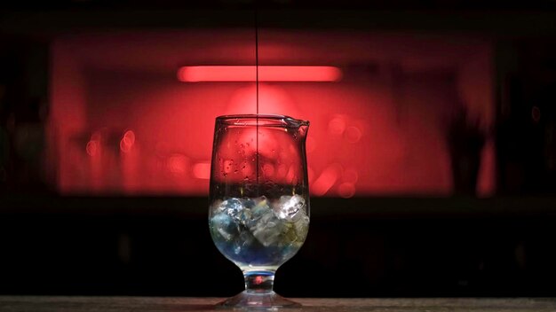 Foto verter bebida alcohólica fresca en el vaso con cubos de hielo en el mostrador del bar imágenes de stock cerca