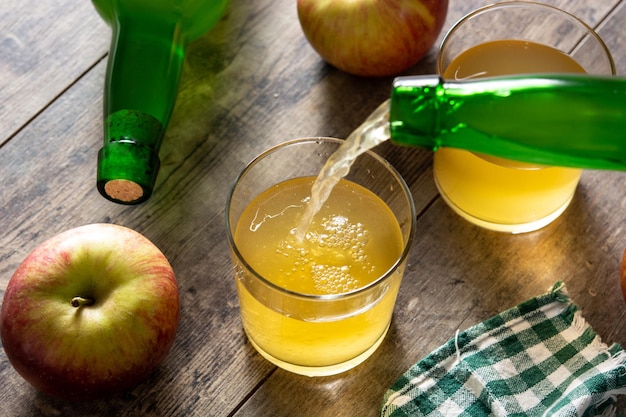 Verter la bebida de sidra de manzana en la mesa de madera