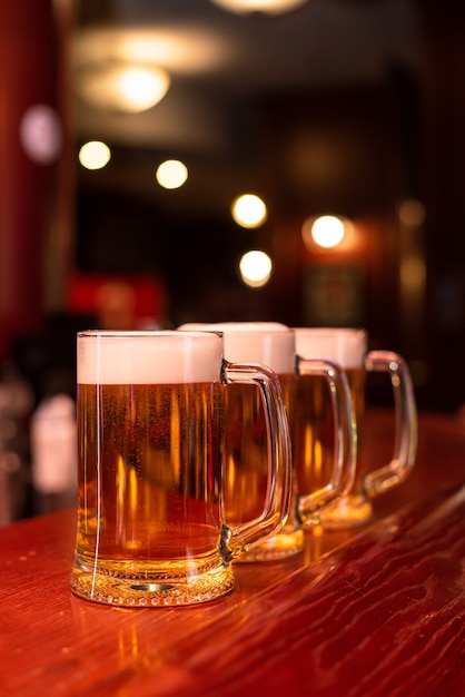 Verter cerveza de pie en la barra del bar brindando cerveza artesanal grande en el pub