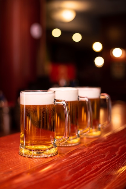 Verter cerveza de pie en la barra del bar. Cerveza artesanal grande en el grifo en el menú de cafetería o pub. Brindando con amigos en el bar