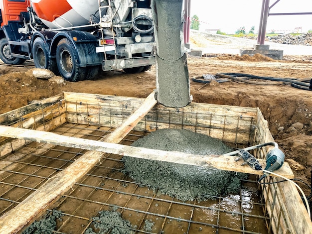 Verter los cimientos con hormigón en el sitio de construcción Trabajos monolíticos de hormigón armado durante la construcción del edificio.