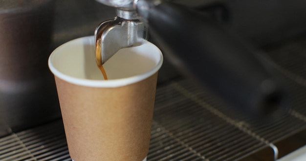 Verter el flujo de café de la máquina en la taza Café recién molido que fluye Beber café negro tostado por la mañana