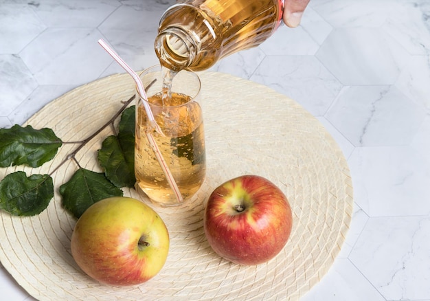 Verter jugo de manzana en una copa de vidrio de una botella Orientación horizontal