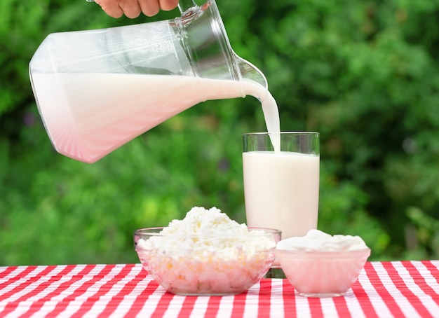 Verter la leche de una jarra en un vaso