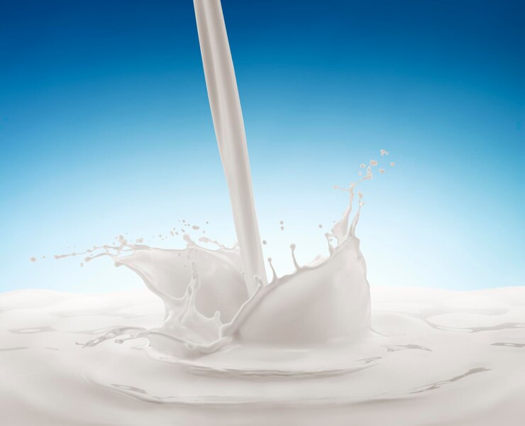 Verter la leche salpicando con fondo azul.