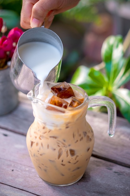 Verter la leche en un vaso con café con leche y helado