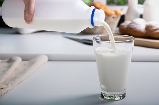 Verter la leche en un vaso en la cocina.