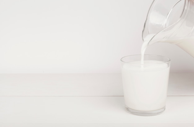 Foto verter la leche en un vaso con espacio de copia