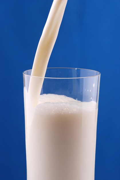 Foto verter leite no fundo azul