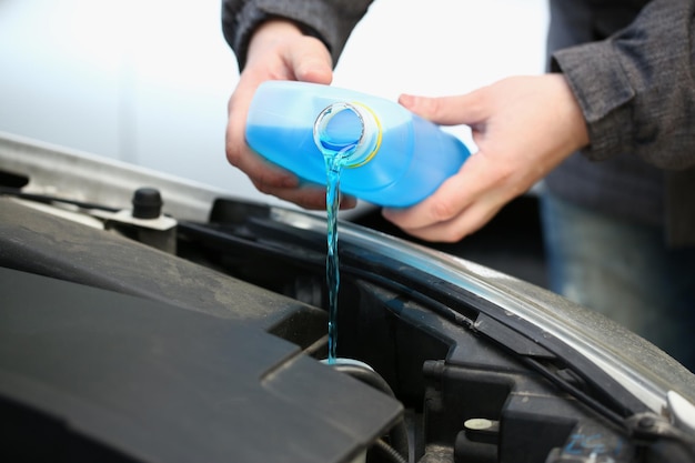 Verter líquido anticongelante azul para lavar el cristal del coche de cerca