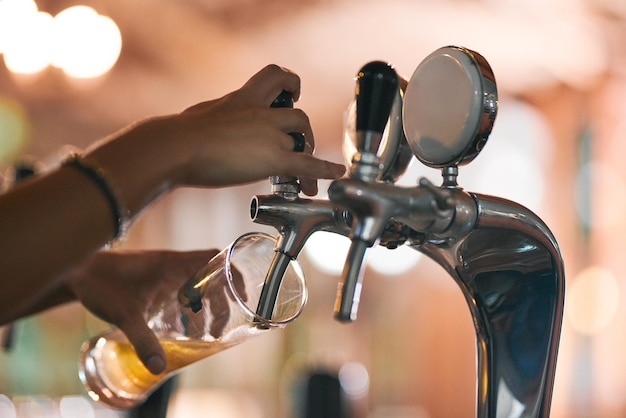 Verter el primero del día Toma de una persona irreconocible sirviendo una cerveza de un grifo dentro de una cervecería durante el día