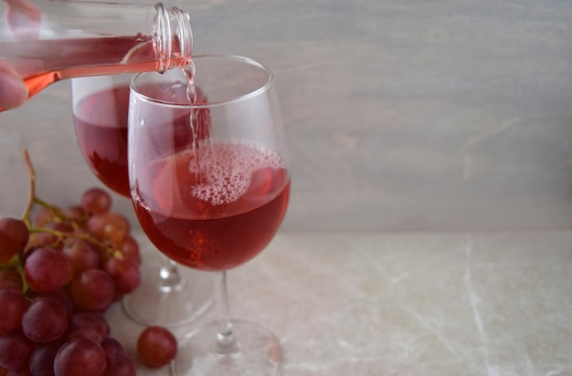 Verter vino tinto con uvas y espacio de copia