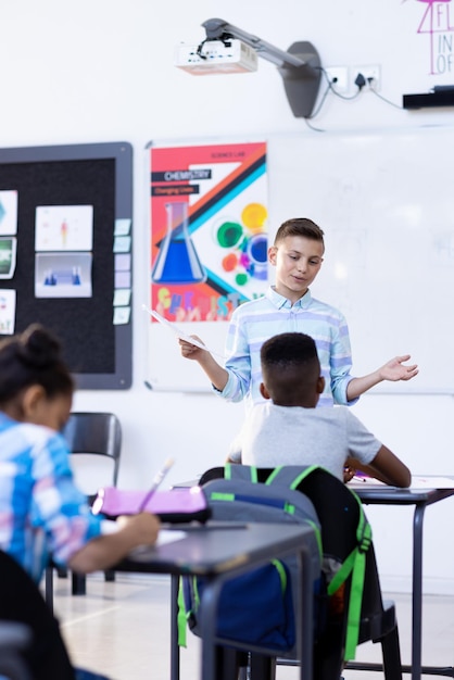 Vertical de dos escolares diversos en discusión durante la clase con espacio de copia