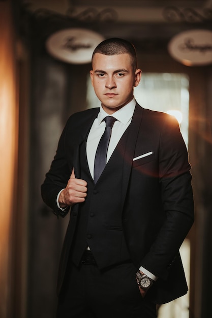 Vertical de un joven bosnio posando en un elegante traje negro