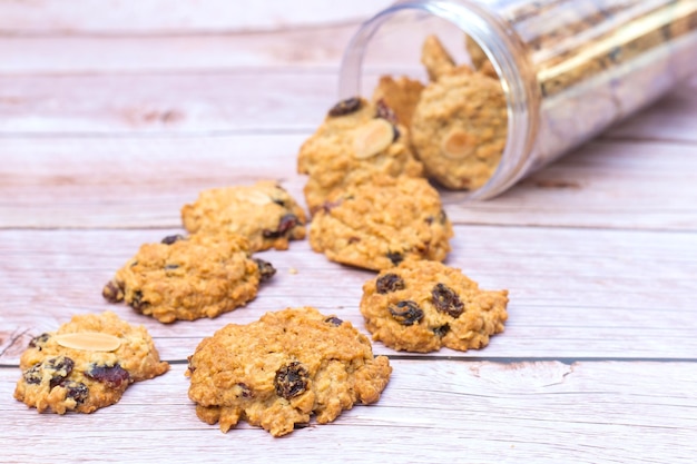 Se vertieron galletas de mantequilla con pasas negras en la mesa de madera de una botella de plástico.