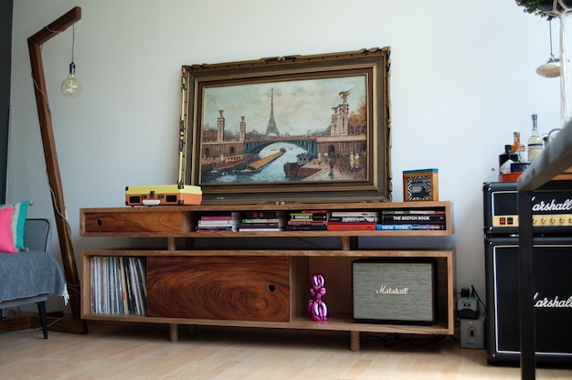 Vertikale Ansicht des gemütlichen Wohnzimmers mit Vinyl-Player auf hölzernem Sideboard mit Büchern
