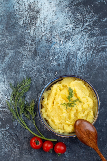 Foto vertikale ansicht von kartoffelpüree serviert mit dillholzlöffel frische tomaten auf dunklem hintergrund mit freiem platz