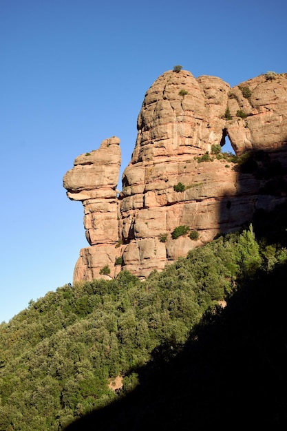 Vertikale Aufnahme der Felsformation auf dem Berggipfel La Cadireta vor blauem Himmel