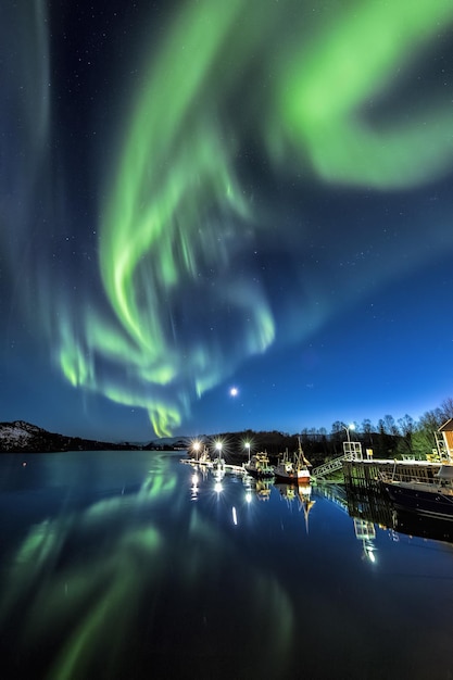 Vertikale Aufnahme der Reflexion der farbenfrohen Nordlichter im Wasser