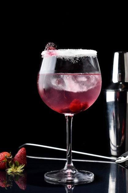 Foto vertikale aufnahme eines cocktails mit brombeere, himbeeren, erdbeeren, mit flasche und löffel