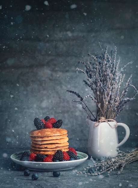 Vertikale Aufnahme eines köstlichen Frühstücks mit Pfannkuchen und Beeren