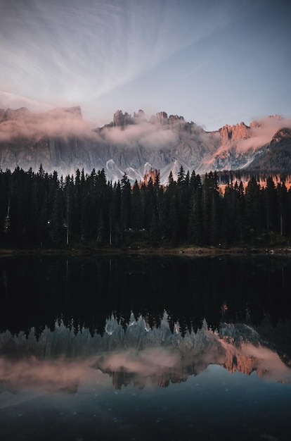 Vertikale Aufnahme eines Sees, umgeben von den Dolomiten und viel Grün in Südtirol Italien